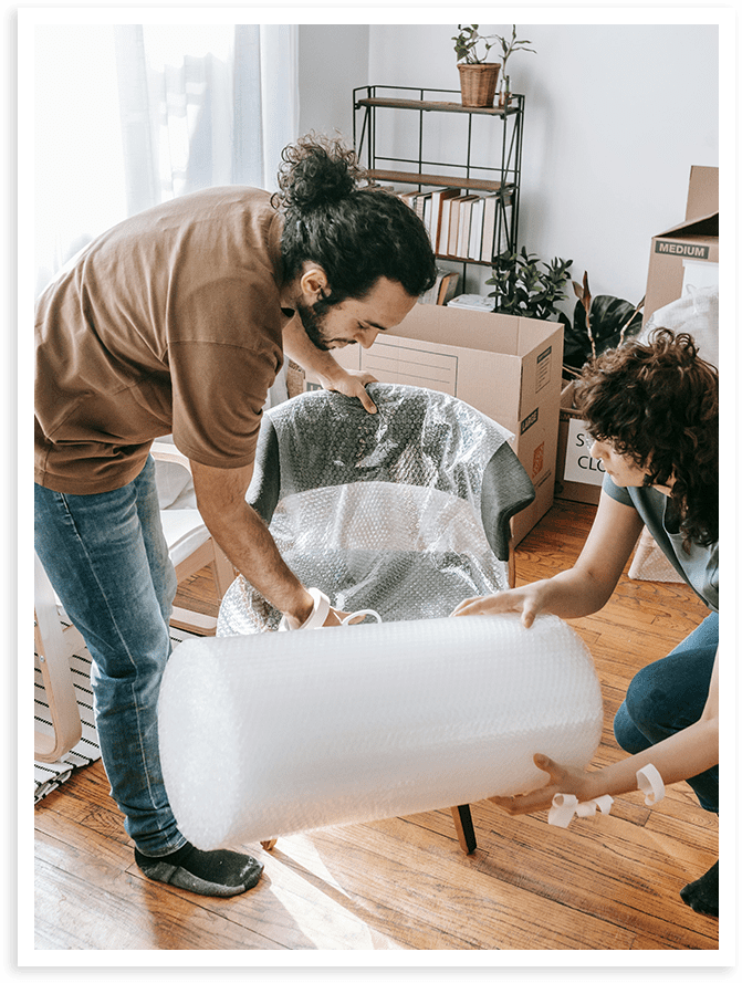 Two people moving a large object in a room.