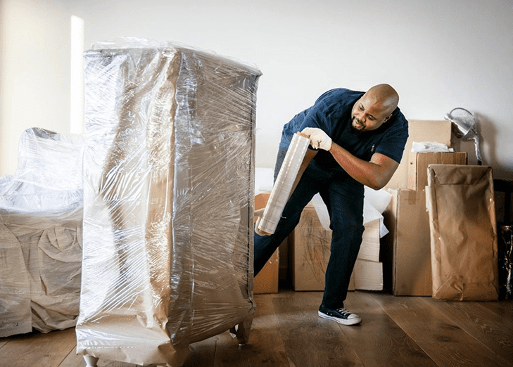 A man is moving boxes on the floor