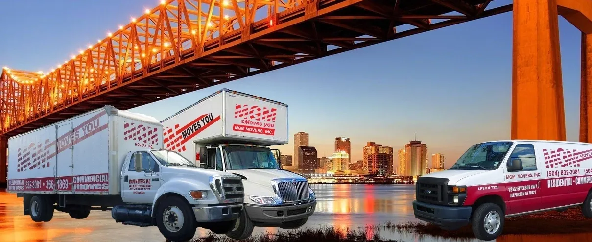 A truck is driving under an overpass in front of the city.