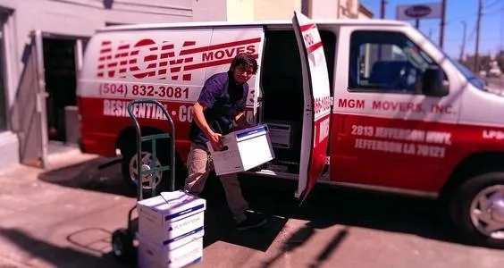 A man loading boxes into the back of a moving van.