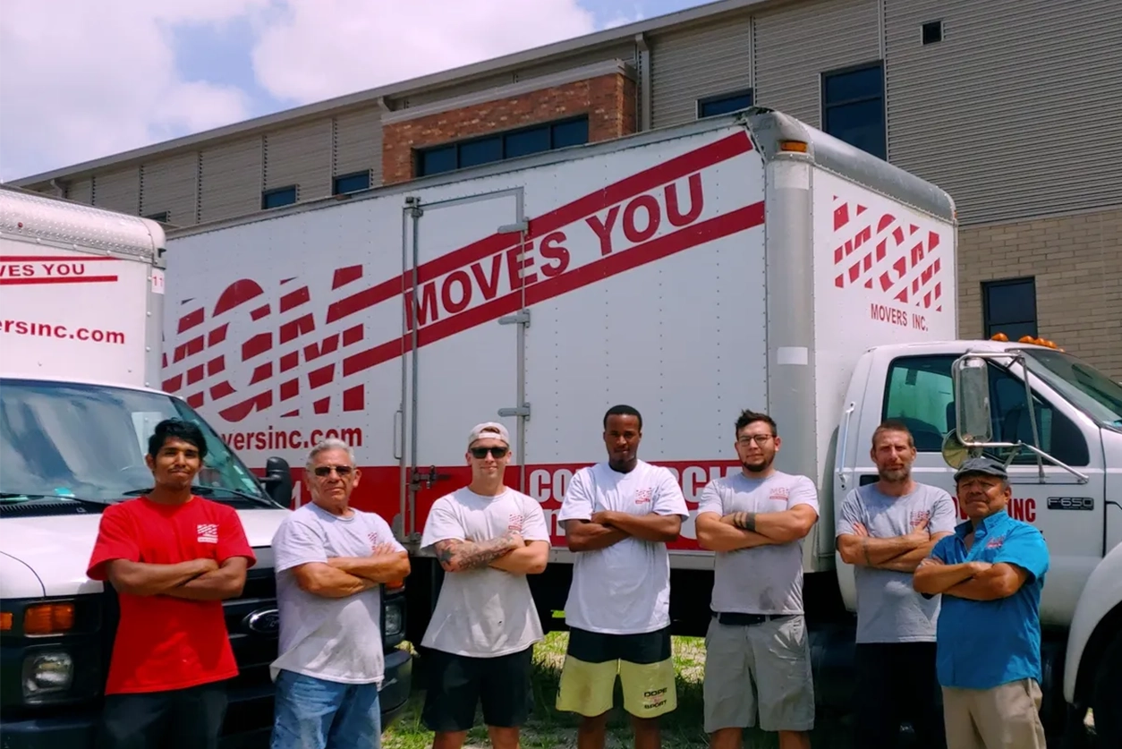 A group of men standing in front of a moving truck.